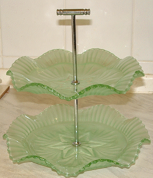 Sowerby 2455 double layer green satin cakestand shown in 1956 catalogue
With chrome handle. 230mm high. Now identified as Sowerby [Source: Tony H and Glen on the Glass Message Board]
Chrome handle and extension were made by Wm Lindop of the Birmingham area [Source: Adam D on the Glass Message Board]
GMB topic: [url]http://www.glassmessages.com/index.php/topic,1419.0.html[/url] 
Keywords: Sowerby pressed England