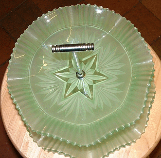 Sowerby 2455 double layer green satin cakestand shown in 1956 catalogue
Top view. 230mm high. Now identified as Sowerby [Source: Tony H and Glen on the Glass Message Board] 
Chrome handle and extension were made by Wm Lindop of the Birmingham area [Source: Adam D on the Glass Message Board]
GMB topic: [url]http://www.glassmessages.com/index.php/topic,1419.0.html[/url] 
Keywords: Sowerby pressed England