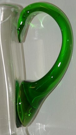 Unknown green/clear footed jug - handle detail
Unknown maker. Has polished pontil. Body of jug is optic ribbed. 7" tall, top is 5" diameter.
Keywords: mouldblown